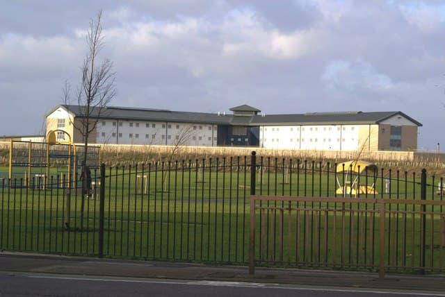 Exterior of HMP Peterborough behind its perimeter fence