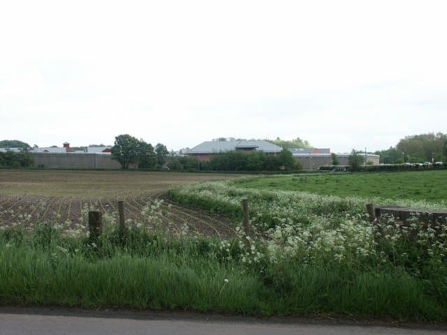 Distant view across fields of the HMP Hewell prison buildings near Redditch