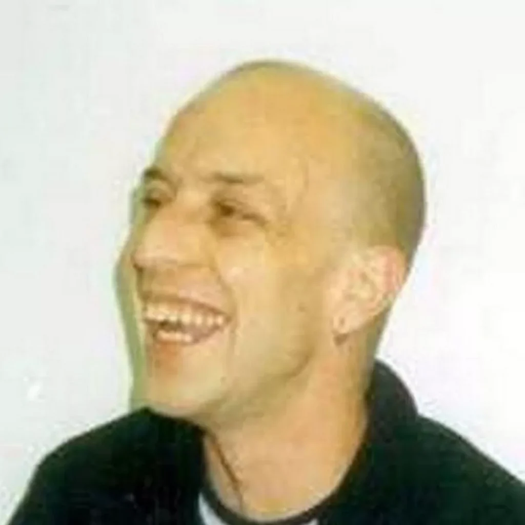 A bald man with a black shirt and a smile.