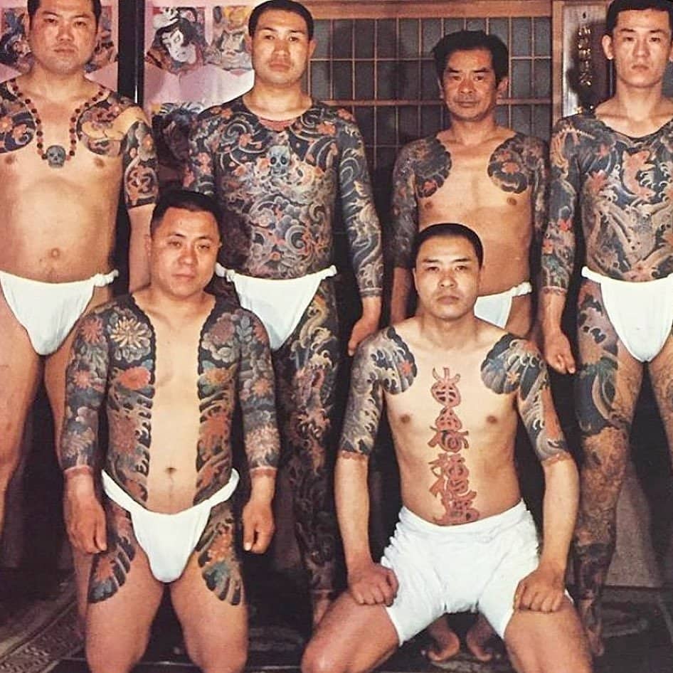 A group of men with tattoos posing for a photo.
